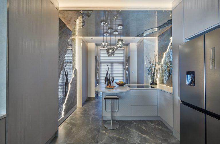 Galley kitchen with a lit stone splashback and a curved breakfast bar