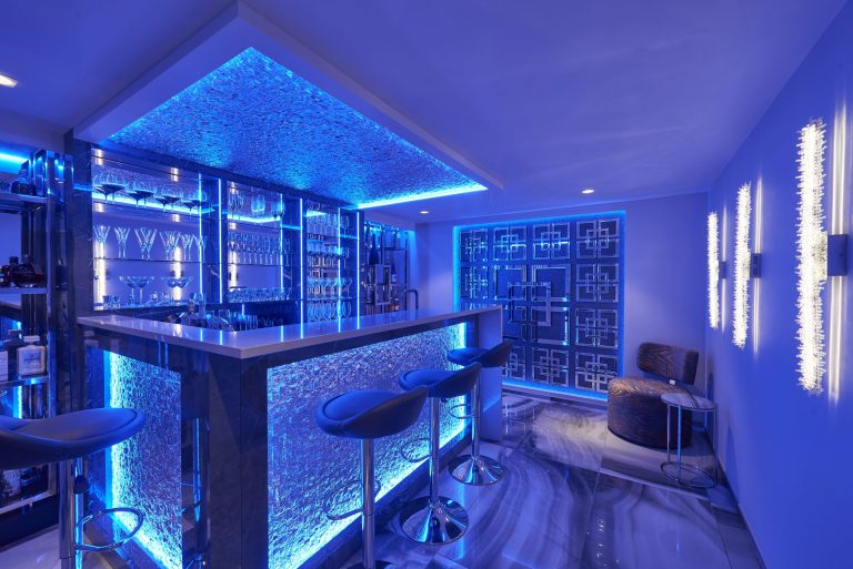 The same basement bar lit blue by its colour-changing lighting