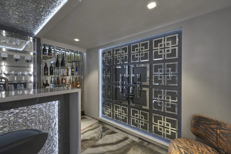 Home bar seen along the room with the fretwork screen wall lit