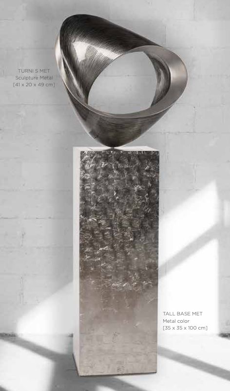 Polished metal loop sculpture on a tall plinth