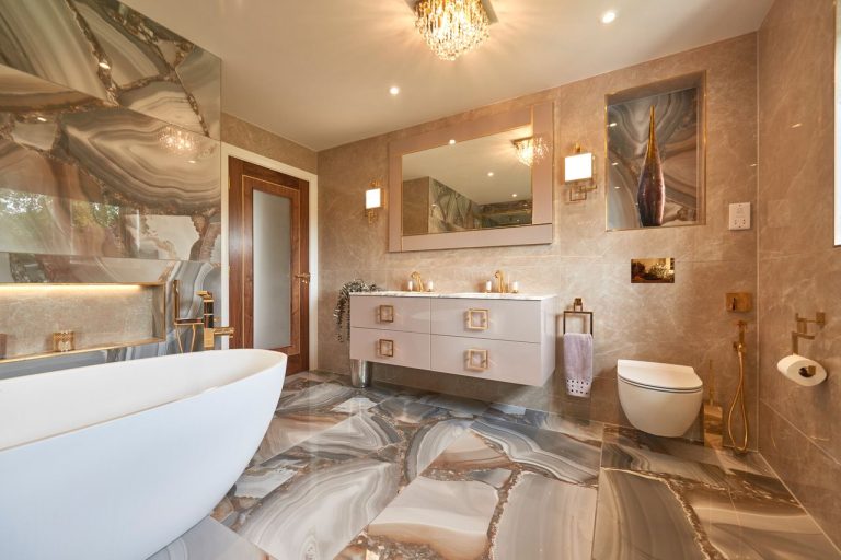 Marble bathroom with a double vanity and a chandelier