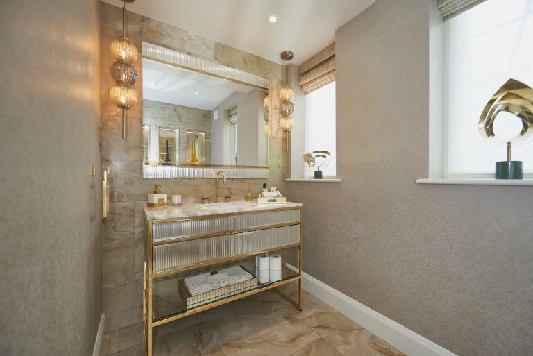 Vanity unit with a lit mirror and brass detailing