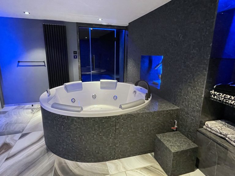Spa room with a jacuzzi and colour-changing lighting