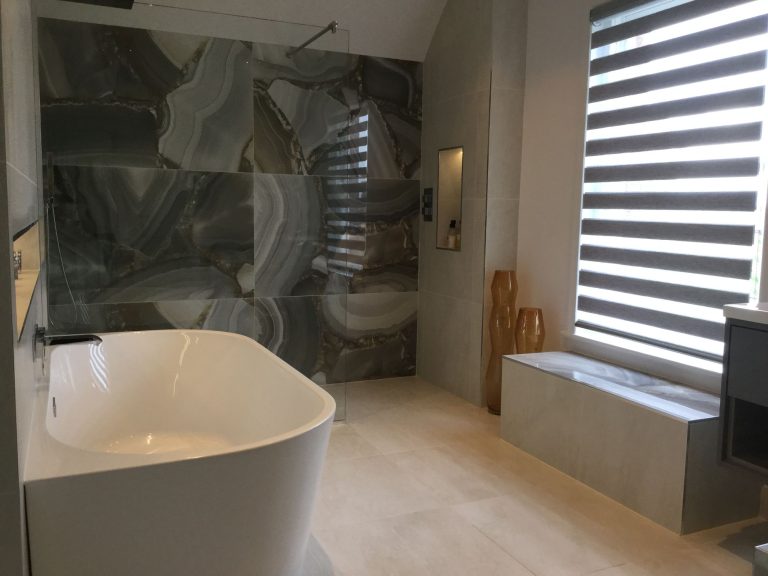 Bath set against a marble wall below a window