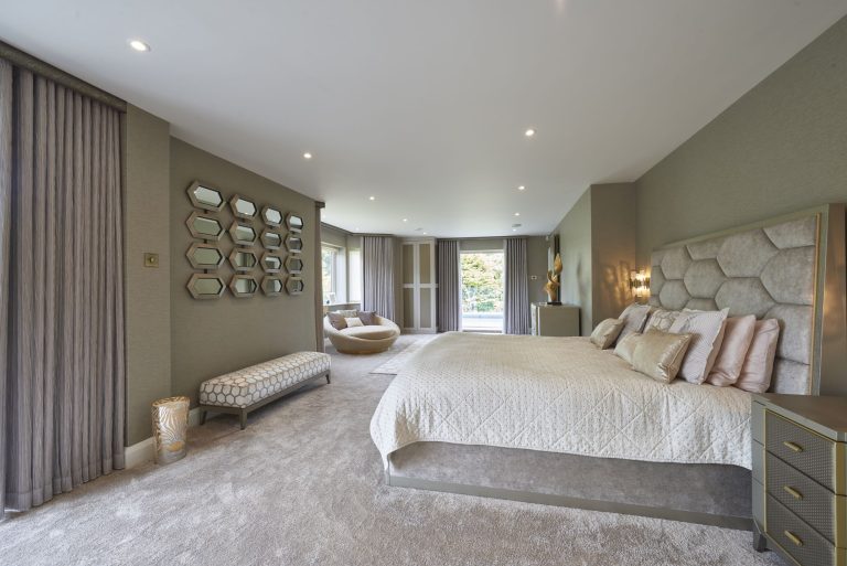 The master bedroom seen along the room, with a group of mirrors on the far wall