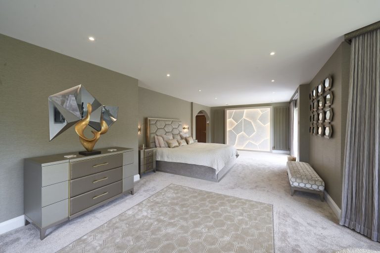 Master bedroom with upholstered wall panels running the full height behind the bed