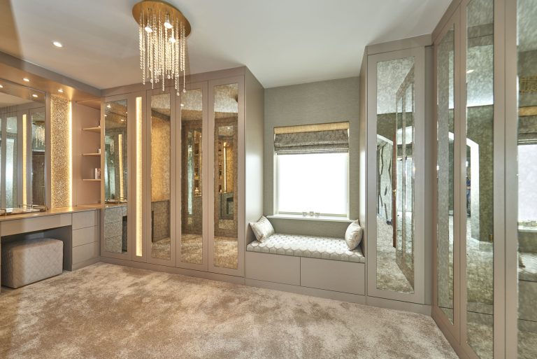 Bedroom with a panelled headboard wall and a long window seat
