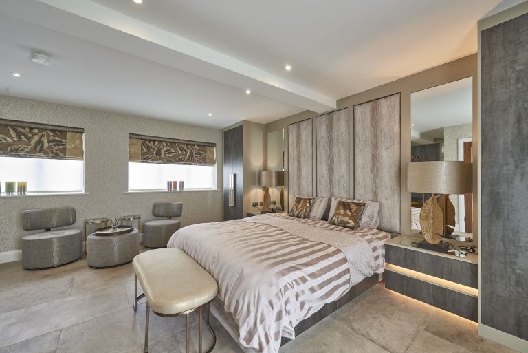 Guest room with panelled walls and a lit dressing unit