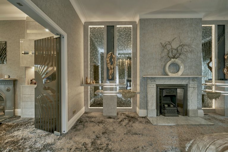 The bedroom seen towards the dressing room doors in bronze glass