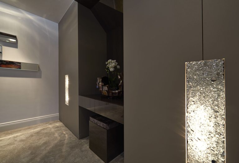 Bedroom with a lit panelled headboard wall