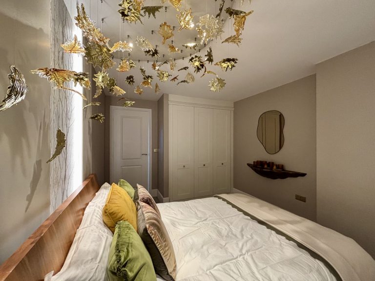 Hand-made glass leaves in amber gold and green seen from the bed
