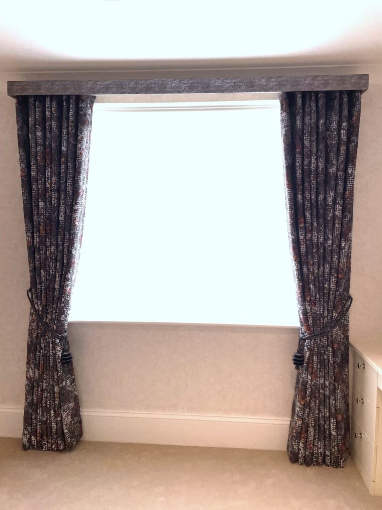 Curtains with tie-backs either side of a bedroom window