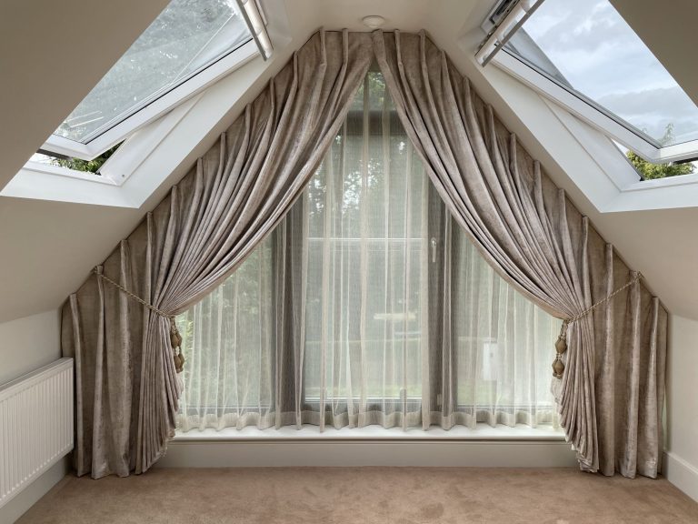 Curtains and sheers fitted to an apex window in a loft bedroom