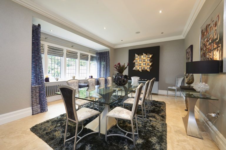 Dining room with a glass-topped table and high-backed chairs