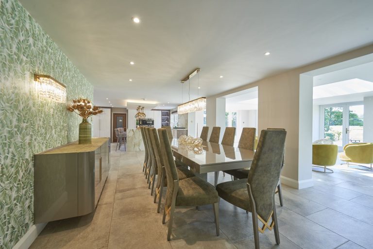 Open-plan dining area with a long table and a patterned wall covering