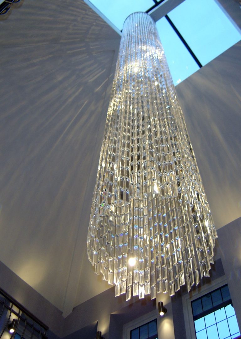Crystal cascade pendant hanging the full height of a double-height hall