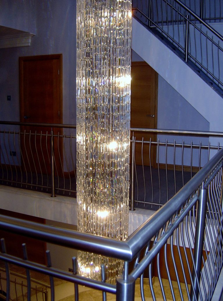 Long crystal pendant beside a staircase and landing balustrade