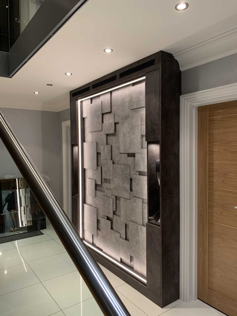 Backlit three-dimensional wall panel beside a staircase