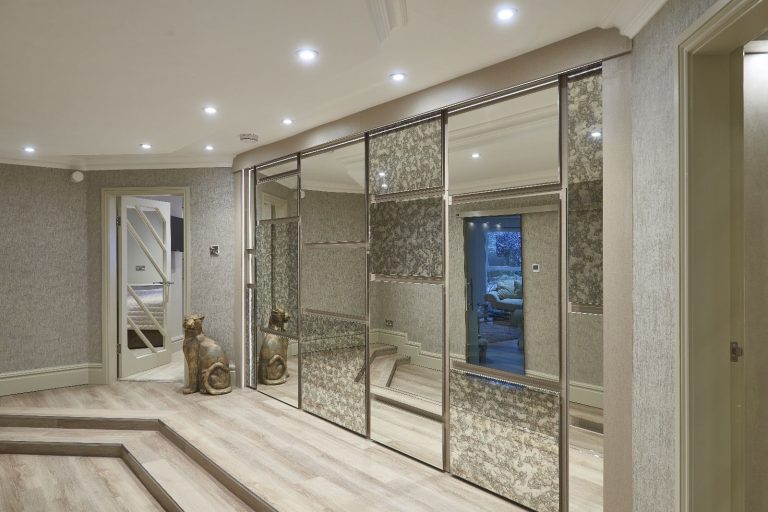Hallway lined with mirrored and textured panel doors
