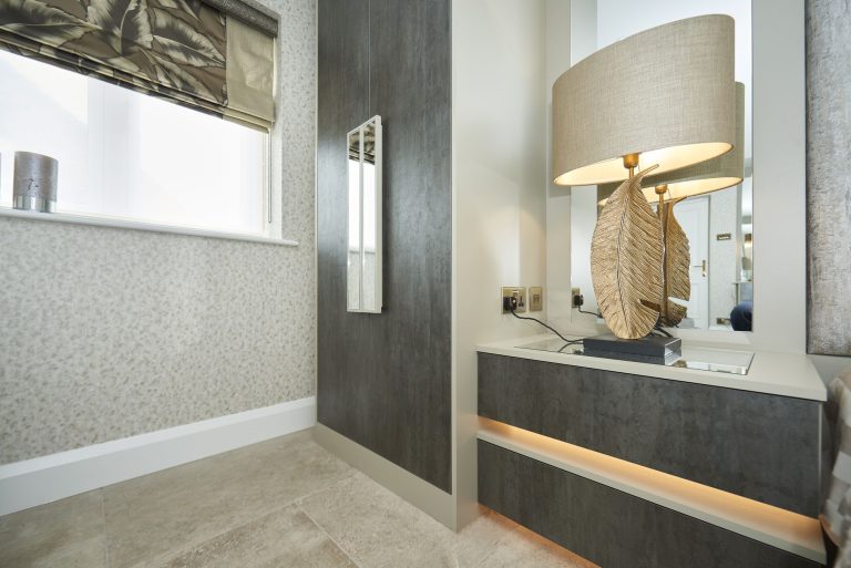 Fitted dressing table and mirror built into a bedroom alcove
