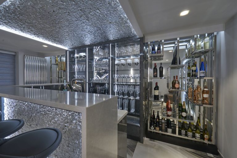 Home bar with a mirrored back wall wine storage and a stone counter