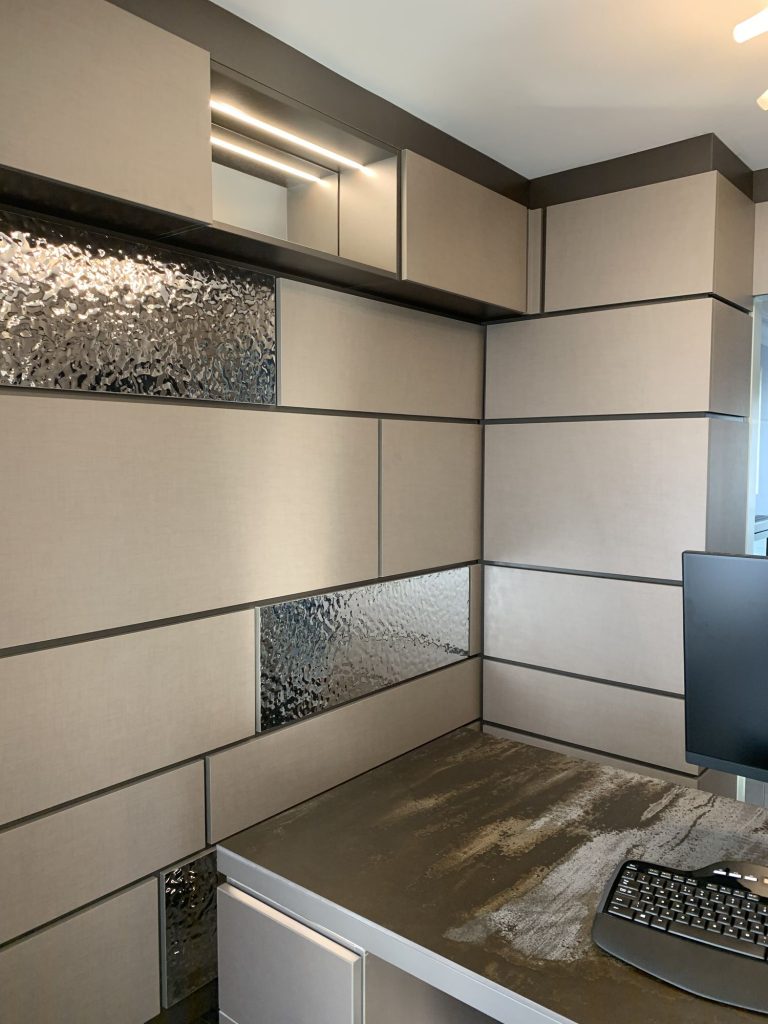 Home study with textured wall panelling and a fitted desk