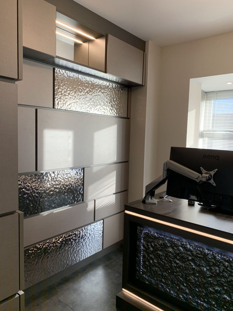 Home office with a fitted desk and sculpted wall panelling