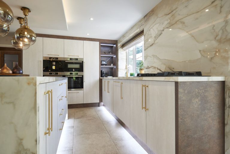 Kitchen with a marble island and brass pendant lights