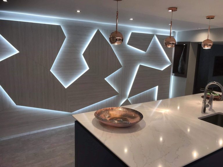 Kitchen with a backlit geometric wall panel above the worktop