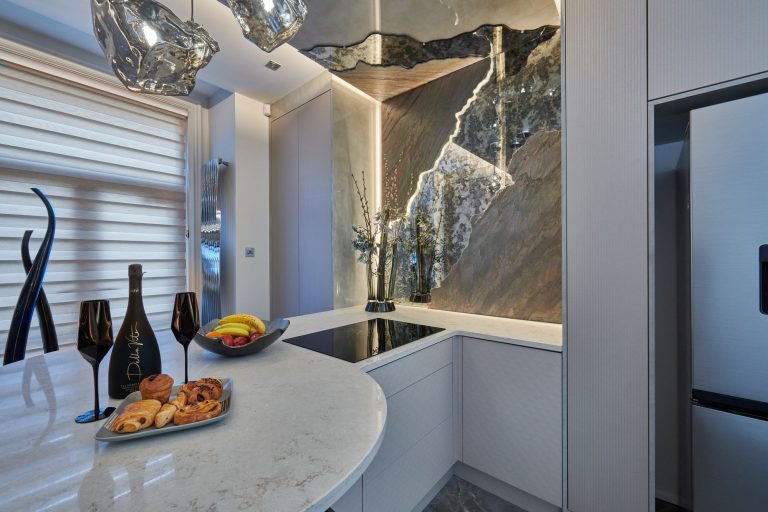 Kitchen with a backlit stone splashback running the full height of the wall