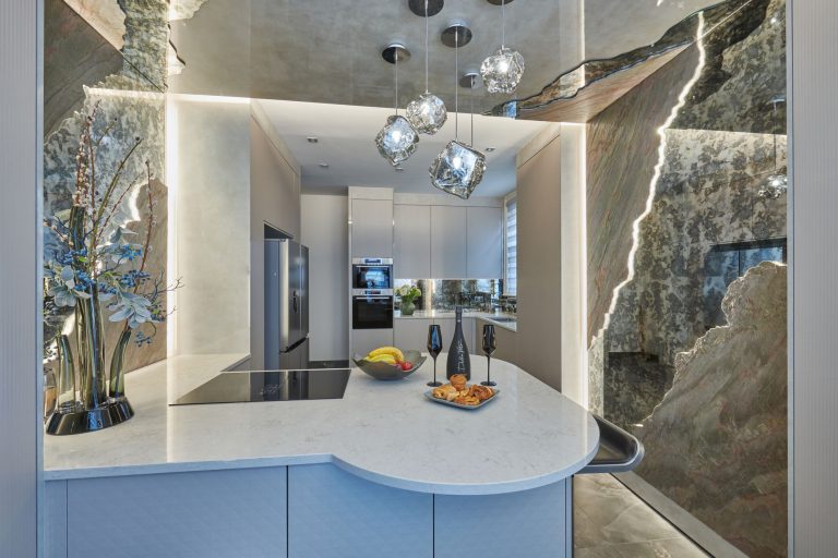The curved end of the island with the hob and the stone wall lit behind