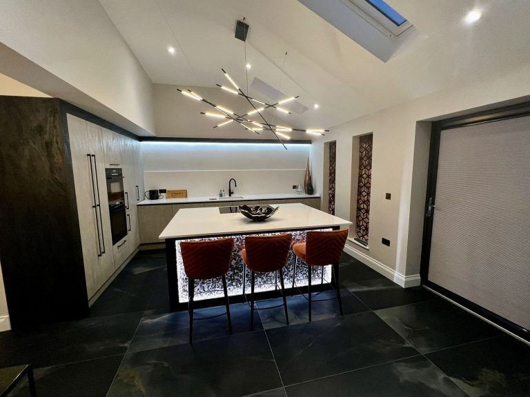 Kitchen island with a lit textured front and a linear pendant above