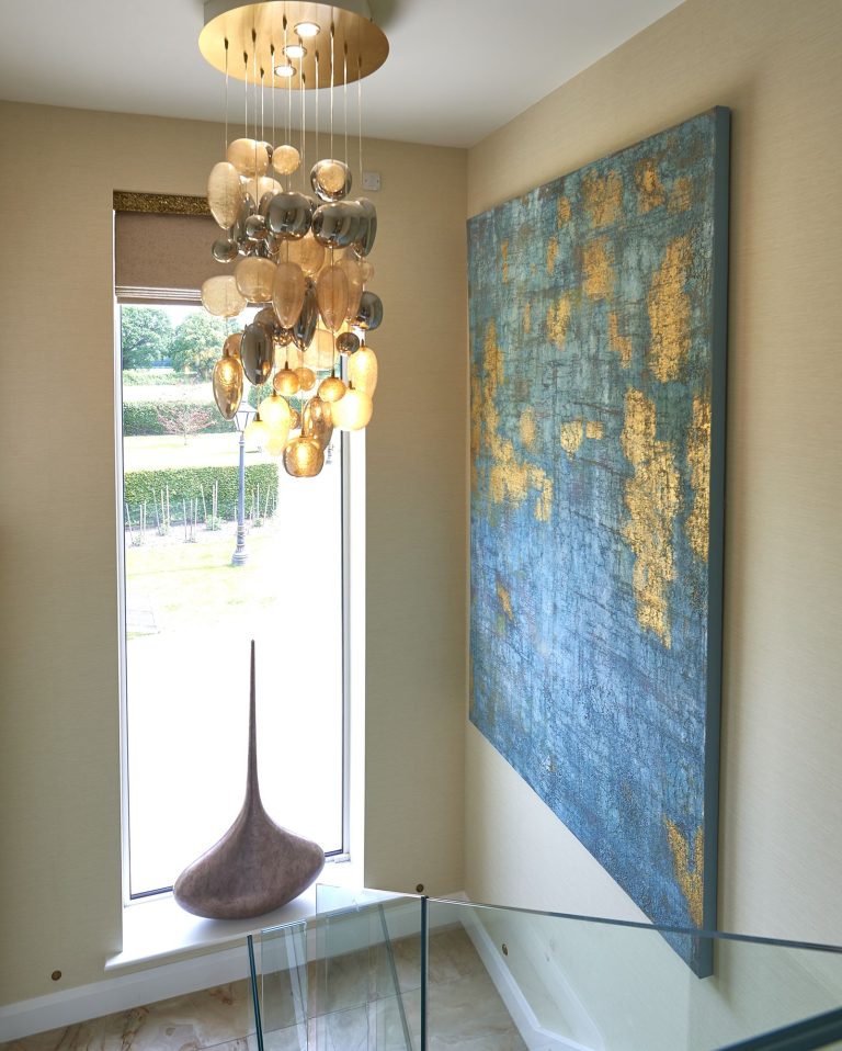 Cluster pendant of gold glass discs in a stairwell