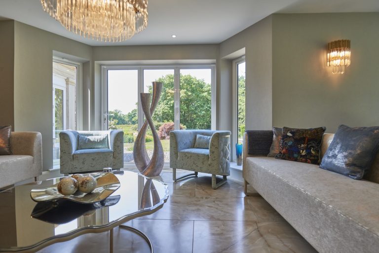 Living room in pale tones with a chandelier and bay window