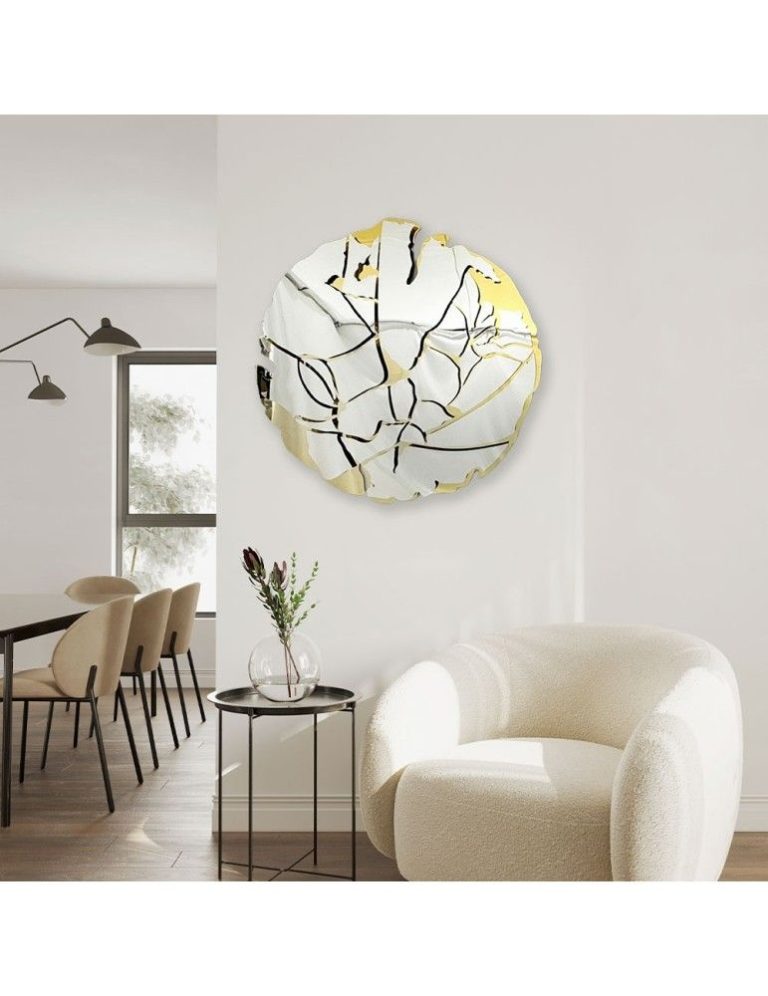 Round decorative wall mirror with an etched glass pattern in a dining room