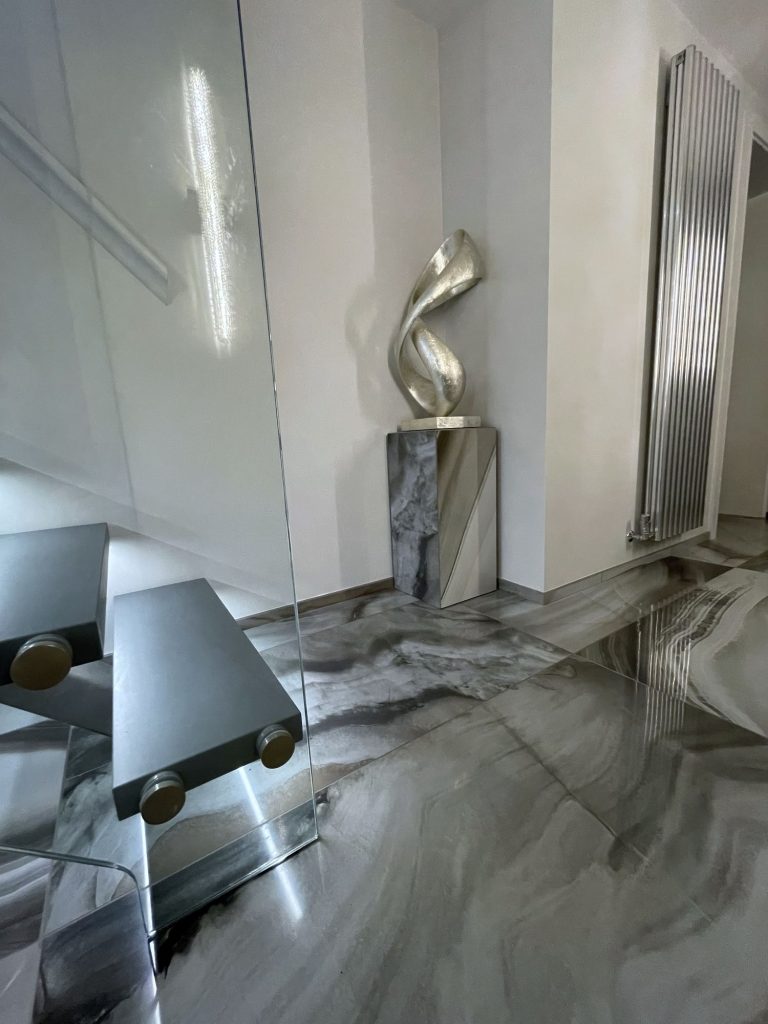 Glass sculpture on a plinth against the onyx floor