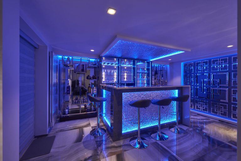 Bar stools at the textured glass counter lit blue