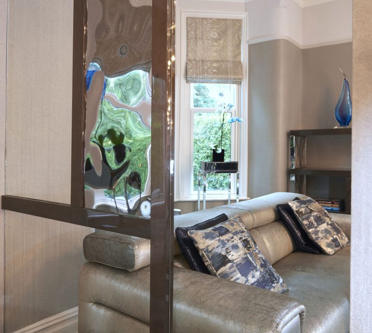 Mirrored panel beside the bay window reflecting the sofa