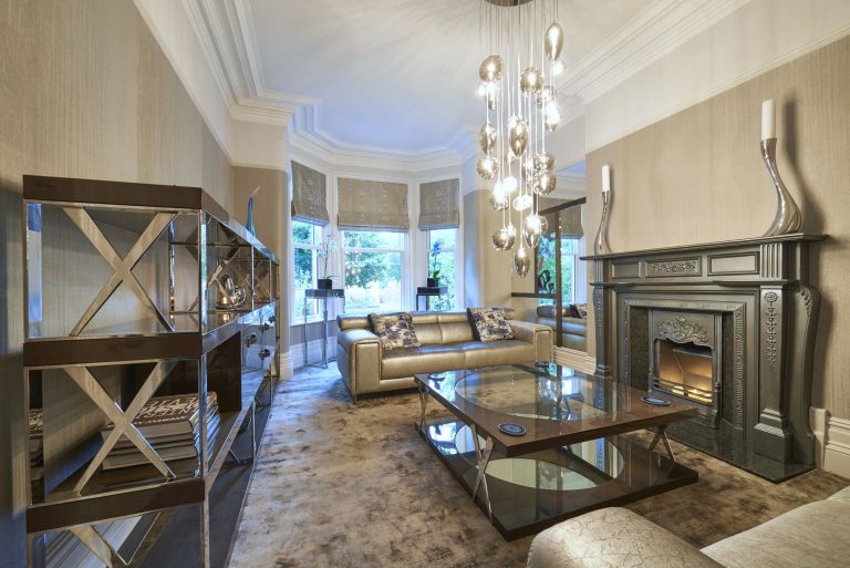 The lounge from the bay window with mirrored screens either side of the fire