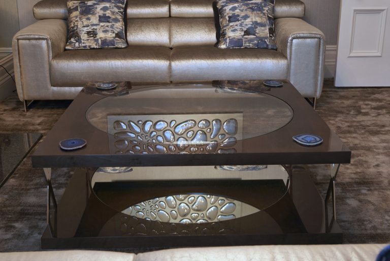 Coffee table with an inlaid top in front of the leather sofa