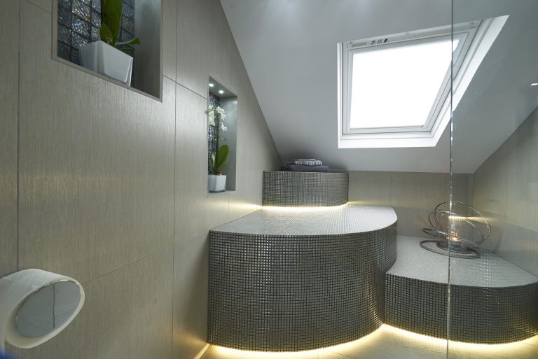 The bathroom seen from the shower, with the mosaic bench lit