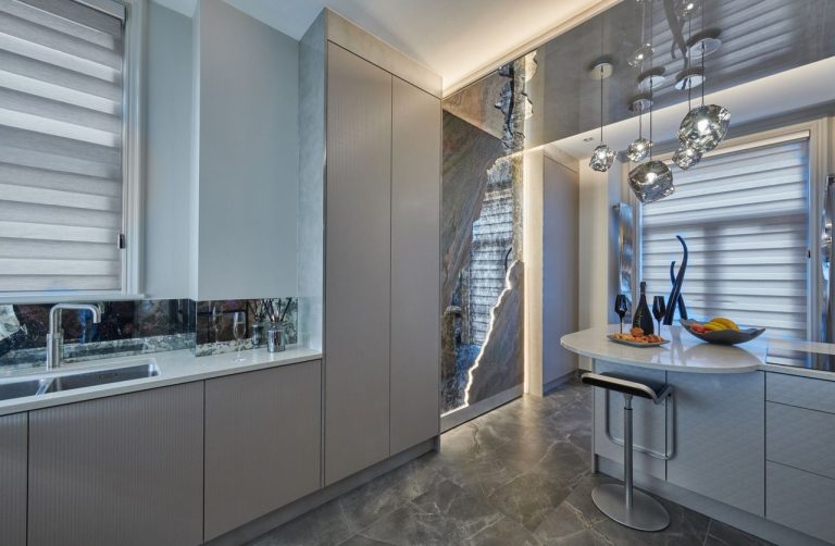 The kitchen towards the window with the lit stone panel along the wall