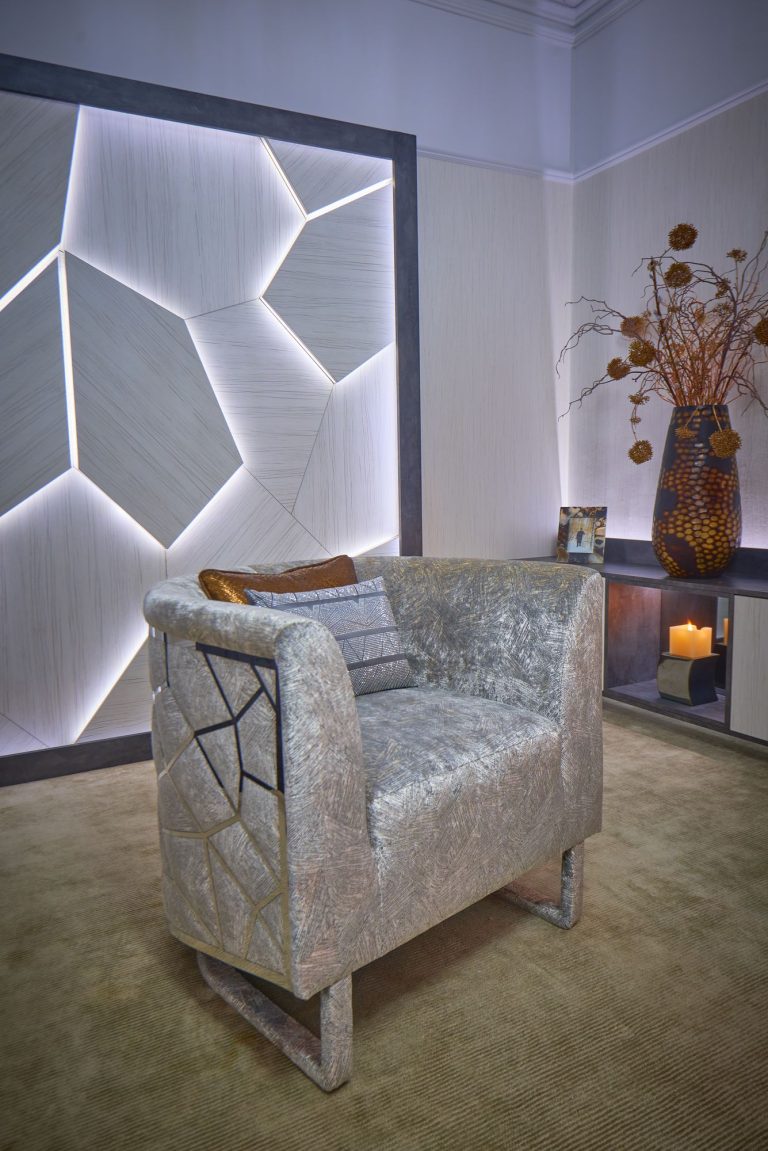 Armchair and console against the lit panel