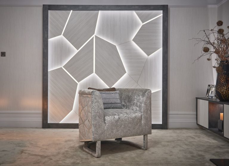 Crushed velvet armchair beside the backlit wall panel