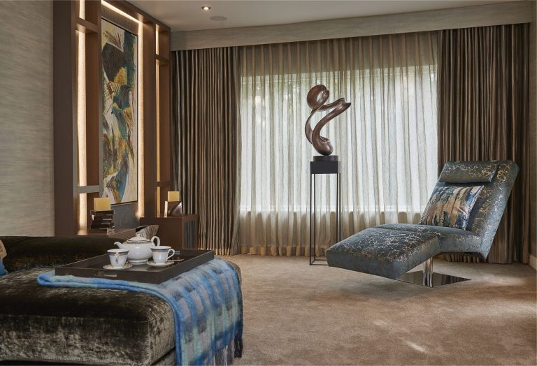 Chaise longue and sofa with a bronze sculpture between the curtains