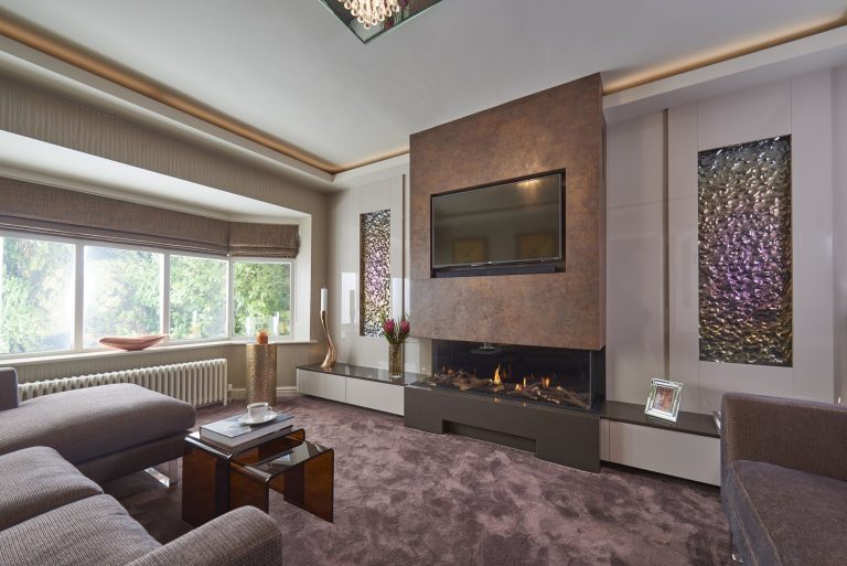 The snug with a linear fire below a stone panel and artwork either side