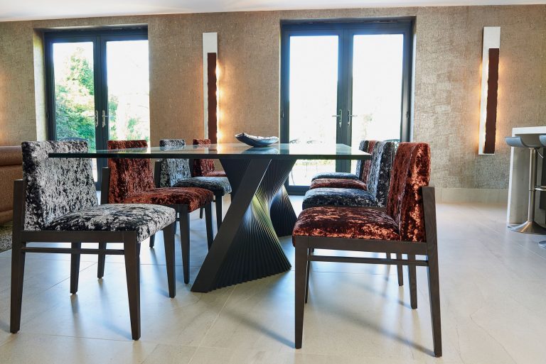 Patterned velvet dining chairs against a neutral window treatment