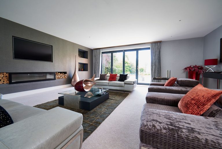 Sitting room with a wall-hung television and log storage niches