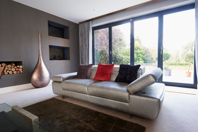 Silver leather sofa with copper floor lights beside the window