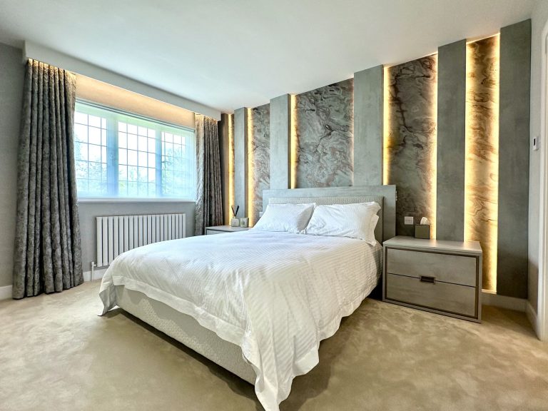 Compact bedroom with illuminated slate veneer panels behind the bed